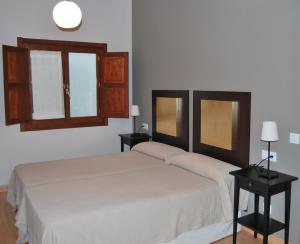 una camera con due letti e due tavoli con lampade di Apartamentos Plaza Mayor a Llanes