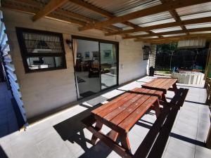two picnic tables on a patio with a building at Arch Cabins Self Catering Homes Storms River in Stormsrivier