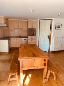 kuchnia z drewnianym stołem w środku w obiekcie Maison studio avec jardin w mieście Salers