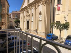 a balcony of a building with cars parked on a street at Il portale in Tropea +10 photos