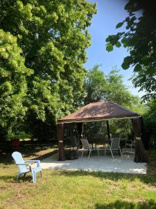 einen Pavillon mit Stühlen und einem Tisch in einem Park in der Unterkunft Le petit monas in Civaux
