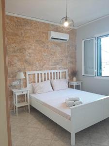 1 dormitorio con 1 cama blanca grande y 2 mesas en Evelina 4 en Lixouri