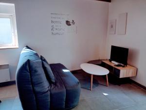 uma sala de estar com um sofá azul e uma mesa em Le Duplex, parking wifi aux portes de vannes em Vannes