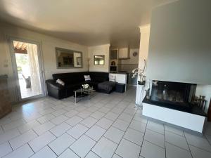a living room with a couch and a fireplace at HAUT DE VILLA AVEC PISCINE privative ET APPARTEMENT REZ DE CHAUSSEE in Le Tignet