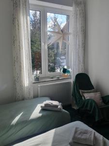 a bedroom with a bed and a window and a chair at Porębana Osada in Długopole-Zdrój