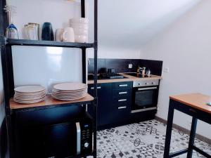 eine Küche mit einer Mikrowelle und einer Theke mit Tellern in der Unterkunft Le Duplex, parking wifi aux portes de vannes in Vannes