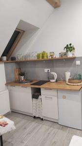 a kitchen with white cabinets and a wooden counter top at Porębana Osada in Długopole-Zdrój