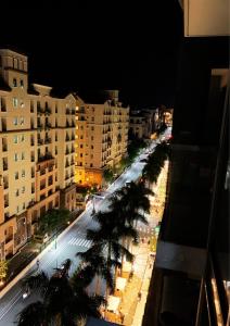 a city street with palm trees and buildings at night at Studio 8th FL with Balcony across Terminal 3 Airport in Manila