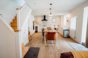 a kitchen and dining room with a table and chairs at Quaint cosy cottage with a hot tub in Tenby centre in Pembrokeshire