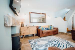 a living room with a couch and a mirror at Quaint cosy cottage with a hot tub in Tenby centre in Pembrokeshire