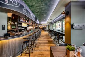 a bar with tables and stools in a restaurant at ibis Styles Hamburg Barmbek in Hamburg