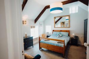 a bedroom with a bed and a mirror on the wall at Quaint cosy cottage with a hot tub in Tenby centre in Pembrokeshire