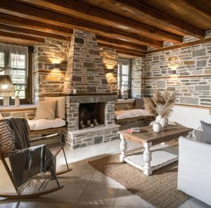 a living room with a stone fireplace at Homstone in Nikiti
