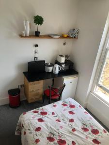 a bedroom with a bed and a desk and a table at Cosy Studio Apartment - Blackheath, Greenwich in London