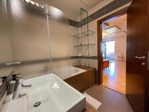 a bathroom with a white sink and a tub at Apartment Felicia 12 in Portorož
