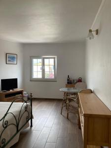 Cette chambre comprend un lit, une table et une fenêtre. dans l'établissement Casa da Nazaré, à Portinho da Arrábida