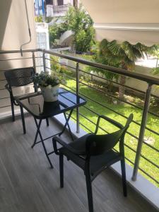 a balcony with two chairs and a table and a plant at TASOS PARADISE in Polychrono