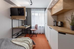 sypialnia z łóżkiem i biurkiem z komputerem w obiekcie Balcia Residence w Rydze