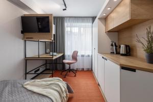 a bedroom with a bed and a desk with a computer at Balcia Residence in Riga
