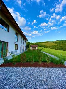 a house with a garden in front of it at Le Cornici - Cascina di Charme in Diano dʼAlba