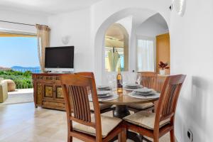 a dining room with a table and chairs and a television at Appartamento Eleganza - SHERDENIA Luxury Apartments in Marinella