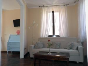 uma sala de estar com um sofá branco e uma janela em Piazza degli Angeli em Assis