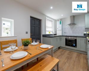 uma cozinha com uma mesa de madeira com placas brancas em Five Bedroom Spacious Modern House By Keysleeps Short Lets Workington Lake District Beach em Workington