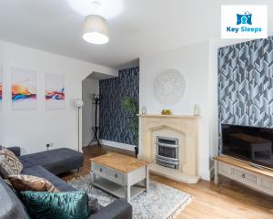 uma sala de estar com um sofá e uma lareira em Five Bedroom Spacious Modern House By Keysleeps Short Lets Workington Lake District Beach em Workington