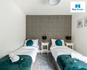 two beds sitting next to each other in a room at Five Bedroom Spacious Modern House By Keysleeps Short Lets Workington Lake District Beach in Workington