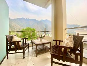 a balcony with two chairs and a table with a view at Tapovan New Residency By FTP Hotels in Rishīkesh
