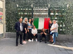 un grupo de personas de pie frente a una pared en Lion Hostel, en Milán