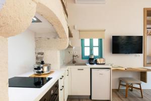 een keuken met witte kasten en een aanrechtblad bij La Luna della Loggia A1 in Rethimnon +12 foto's