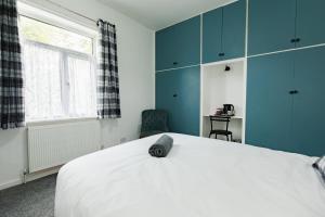 a bedroom with a large white bed with blue cabinets at Peaceful House near Pearson Park in Hull