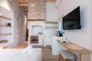 une chambre blanche avec un canapé blanc et une cuisine dans l'établissement La Luna della Loggia A1, à Réthymnon