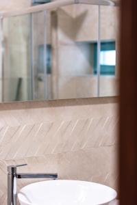 La salle de bains est pourvue d'un lavabo blanc et d'un miroir. dans l'établissement La Luna della Loggia A1, à Réthymnon