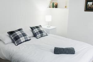 un letto bianco con cuscini bianchi e neri di Peaceful House near Pearson Park a Hull