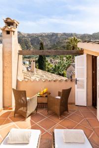 a patio with chairs and a table on a house at Hotel Can Roses in Sóller