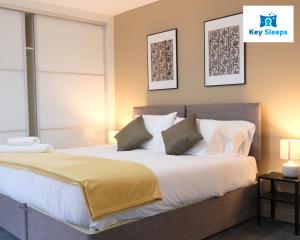 a bedroom with a large bed with white sheets and pillows at Spacious Modern House At Keysleeps Short Lets Northampton With Free Parking Garden 