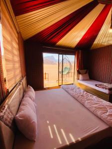 a room with two beds and a view of the desert at Nael Bedouin camp in Wadi Rum
