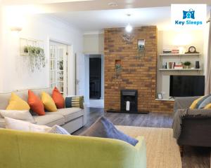 的住宿－Spacious Modern House At Keysleeps Short Lets Northampton With Free Parking Garden，带沙发和壁炉的客厅