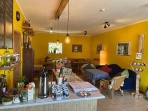 a living room with yellow walls and a table at Pension Grasse Hofladen Cafe GenießerImbiss Kehrigk in Kehrigk