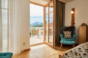 1 dormitorio con cama y vistas a un balcón en Wellness Natur Resort Gut Edermann, en Teisendorf