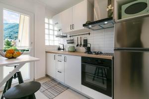 a kitchen with white cabinets and a stove top oven at Terranova beach apartment - Menta in Ýpsos