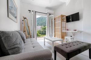 a living room with a couch and a table at Terranova beach apartment - Menta in Ýpsos