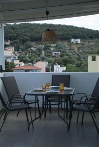 una mesa y sillas en un balcón con vistas en The Artemis House Project, en Artemida