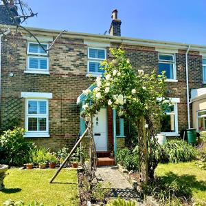 a brick house with a garden in front of it at Garden Cottage - 3 Bedroom Close to Town and Beach in Bournemouth