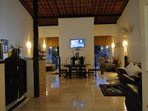 a living room with a couch and a tv in it at Casa de Vidro in Itacaré