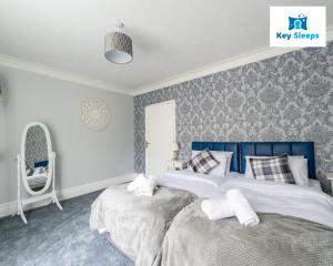 a bedroom with a large bed with a blue headboard at NEW Four Bedroom House By Keysleeps Short Lets Workington Contractor Leisure Beach Location Lake District in Siddick