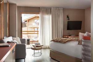 a hotel room with a large bed and a television at Grandes Rousses Hotel & Spa in L'Alpe-d'Huez