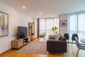 a living room with a couch and a tv at APARTAMENTO Holidea MATALEÑAS in Santander